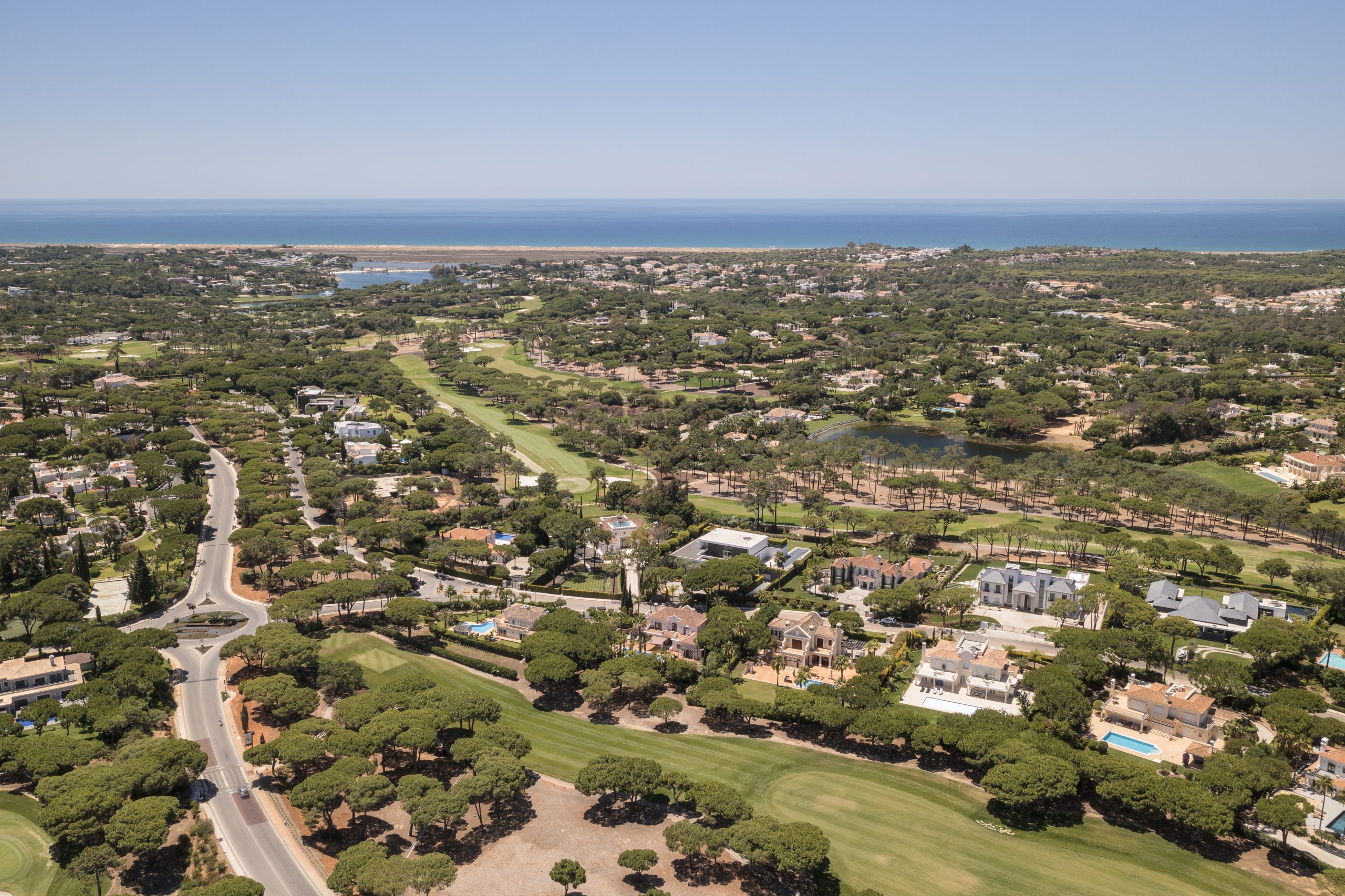 Advertisement image for ONE SELECT PROPERTIES logo and contact details, set against a background of palm trees silhouetted by a beautiful sunset or dusk sky.