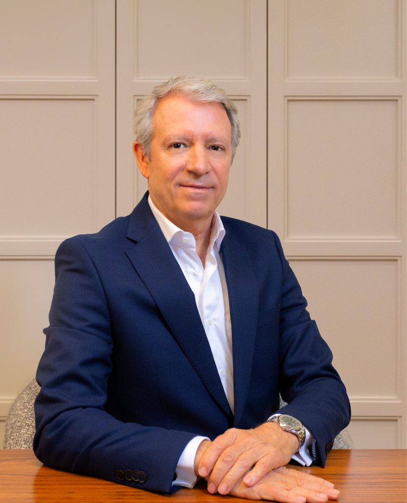 company-director-with-suit-sitting-at-wooden-desk-with-white-background
