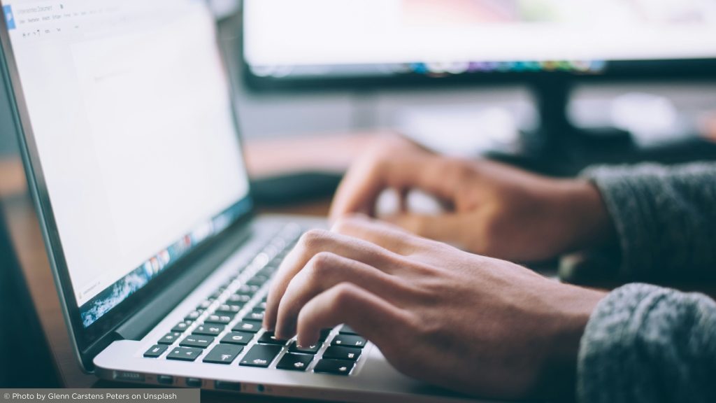 man typing on computer researching visa requirements for portugal residency
