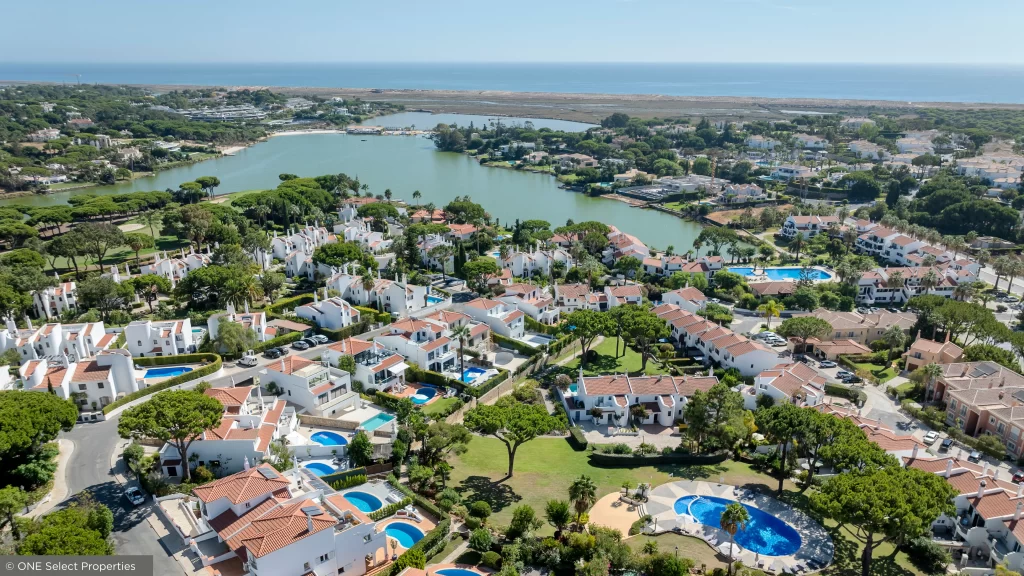 Perspetiva aérea do Lakeside Village na Quinta do Lago com moradias geminadas junto à linha de água.