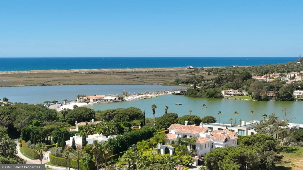Imagem aérea do emblemático lago da Quinta do Lago e do passadiço, com vista sobre a Ria Formosa.