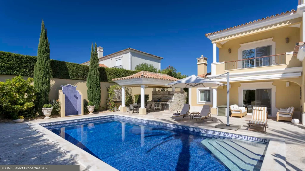 South-facing view of Villa Nina’s heated pool and sun terrace surrounded by landscaped gardens in Quinta do Mar.