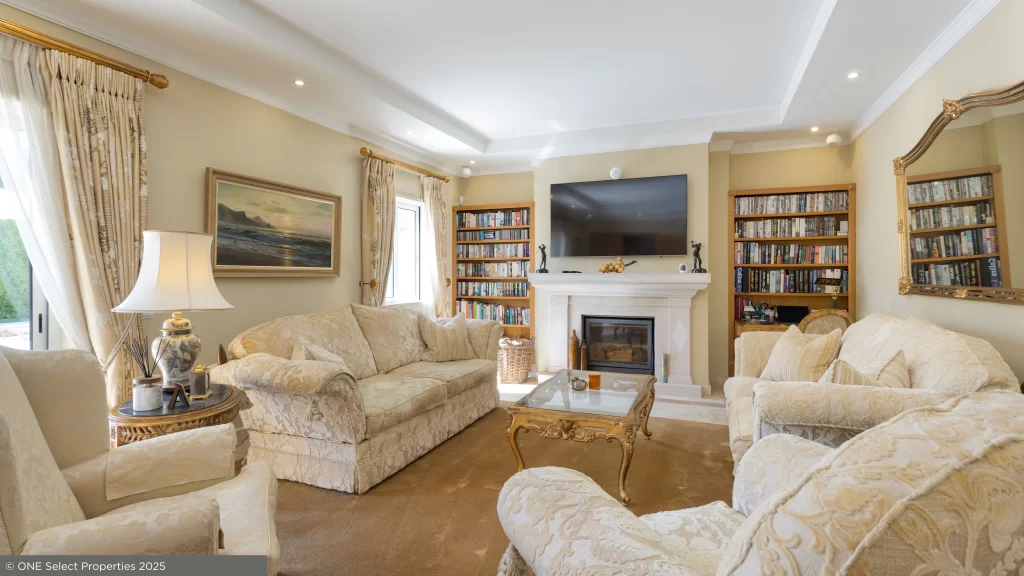 Elegant open-plan living room at Villa Nina featuring wood-burning fireplace and garden views.