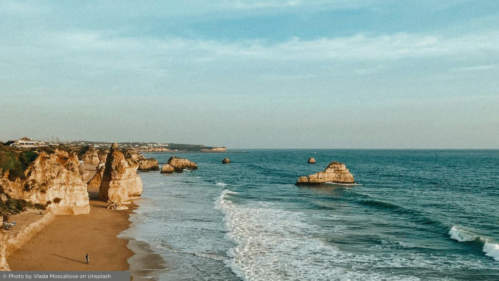 Falésias douradas e ondas do Atlântico ao longo da costa algarvia