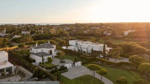 Vista aérea ao pôr do sol da Villa Mirabillis entre pinheiros e moradias contemporâneas na Quinta do Lago.